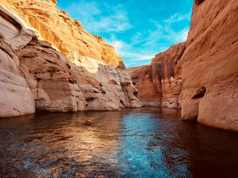 Canyon waterway flowing between towering sandstone cliffs